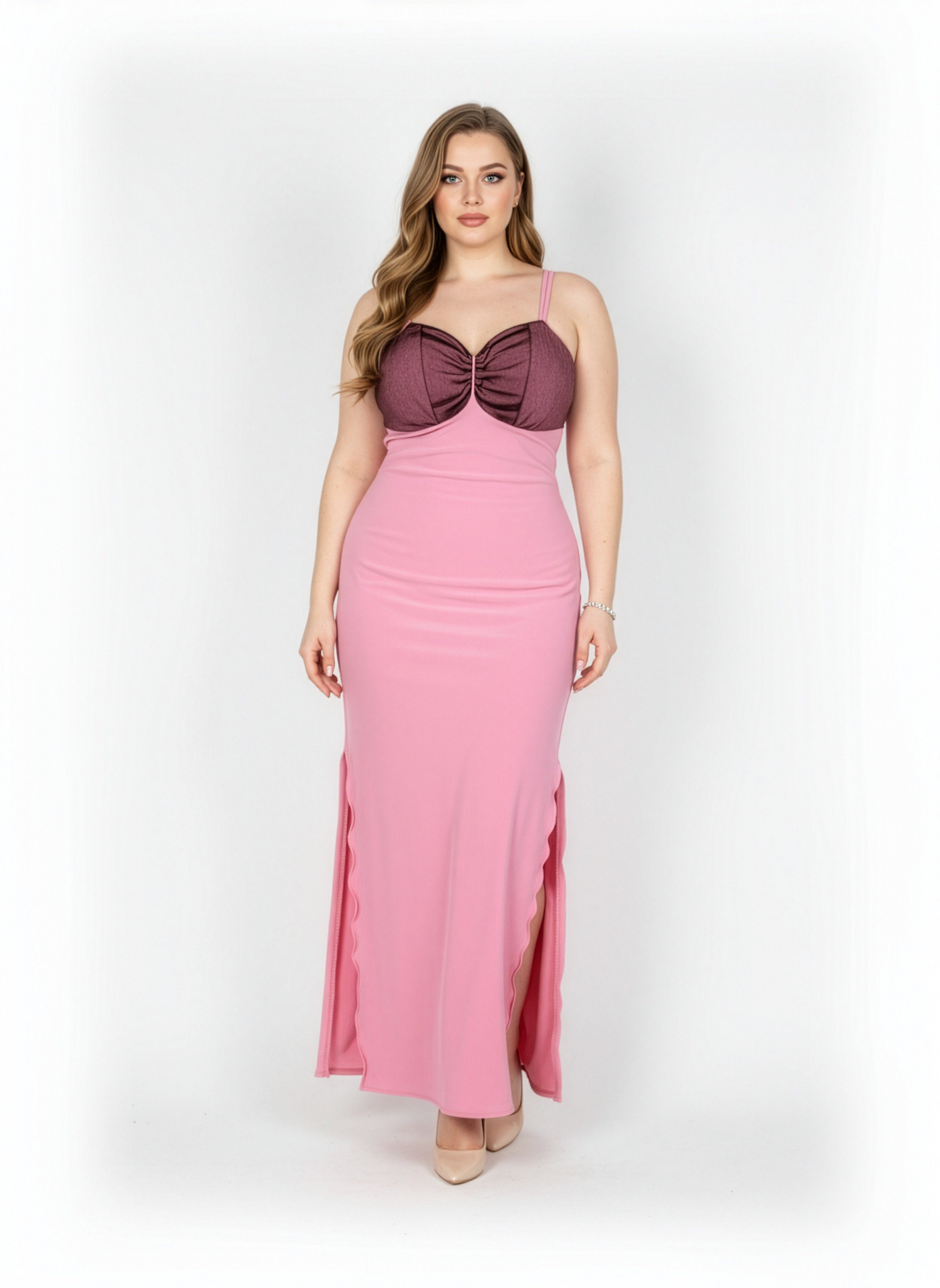 Woman wearing a pink evening gown with a purple bodice on a white background